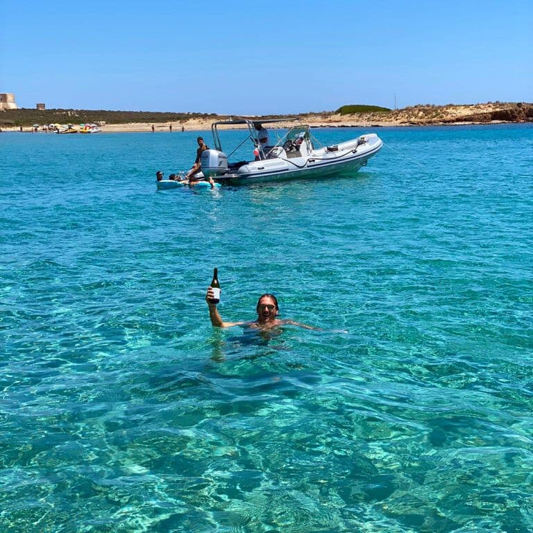 acqua limpida avola con gommone nello sfondo